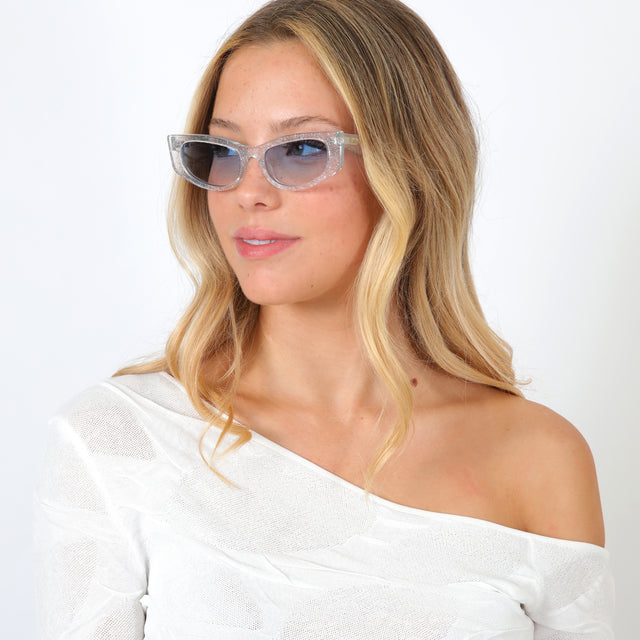Blonde model with loose curls wearing Alexa Sunglasses Silver Blitz with Blue Flat Gradient See Through