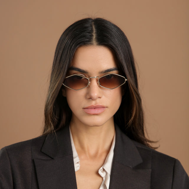 Woman with brown hair in a black blazer wearing Astoria Sunglasses Rose Gold with Brown Flat Gradient