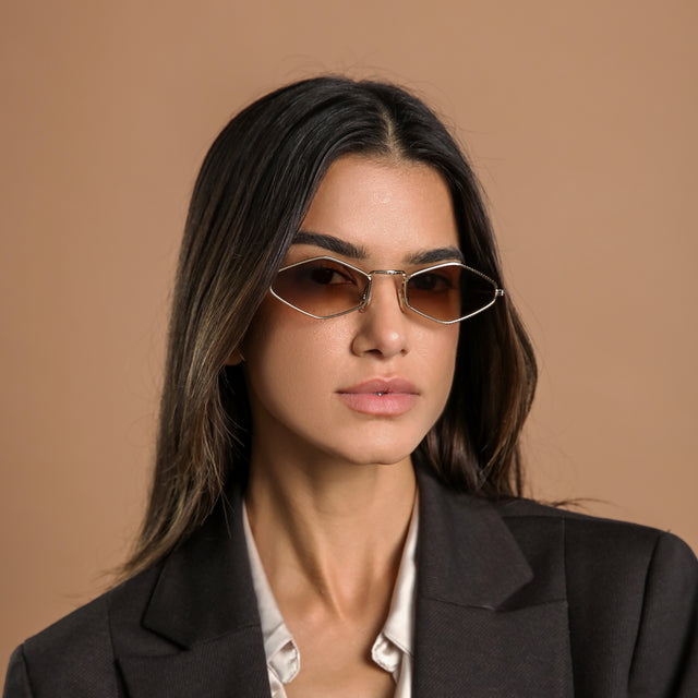 Another angle of woman in a black blazer wearing Astoria Sunglasses Rose Gold with Brown Flat Gradient