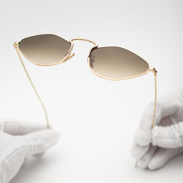 Gloves holding Austria Sunglasses Gold with Taupe Flat Gradient