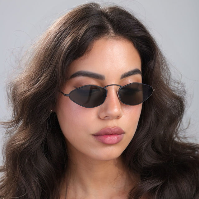 Another angle of brunette woman looking down wearing Austria Sunglasses Matte Black with Grey Flat