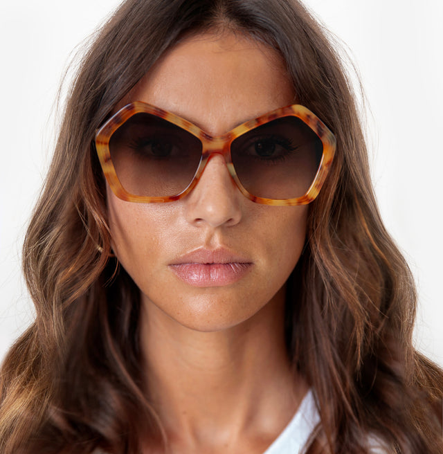 Brunette model with wavy hair wearing Barbra 55 Sunglasses Amber with Brown Flat Gradient