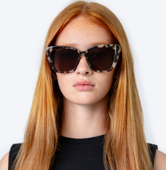 Model with straight red hair wearing Barcelona Sunglasses White Tortoise with Grey Flat