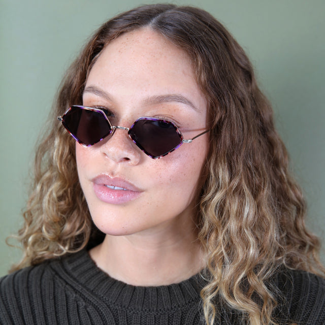 Brunette model with ombré curly hair wearing Beak Ace 53 Sunglasses Berry Tortoise/Gold with Grey Flat