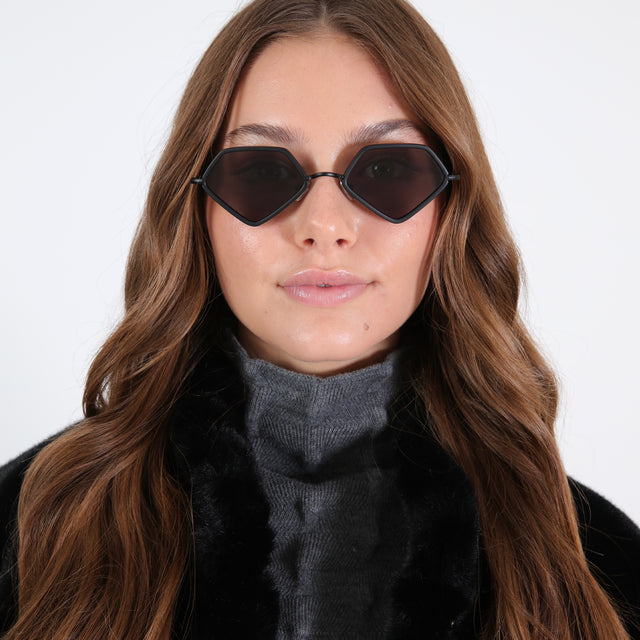 Brunette with curled hair in a black, fuzzy coat wearing Beak Ace 53 Sunglasses Matte Black with Grey Flat