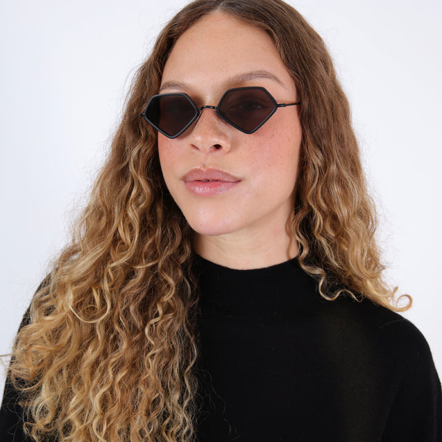 Brunette model with an ombré curly hair in a black sweater wearing Beak Ace 53 Sunglasses Matte Black with Grey Flat