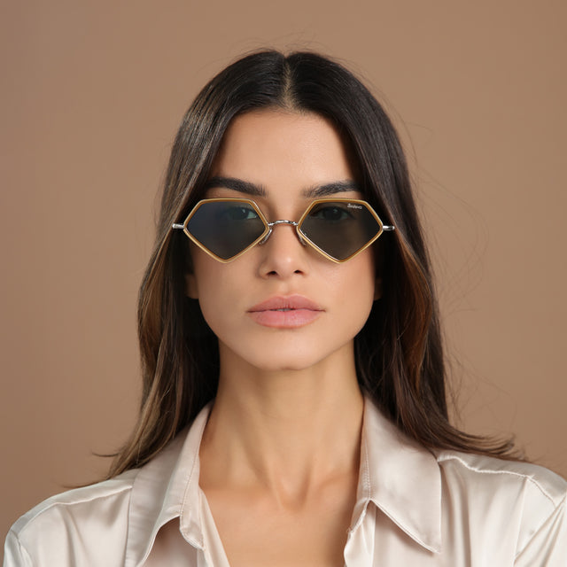 Brunette model in a cream, silk blouse wearing Beak Ace 53 Sunglasses Honey/Silver with Olive Flat