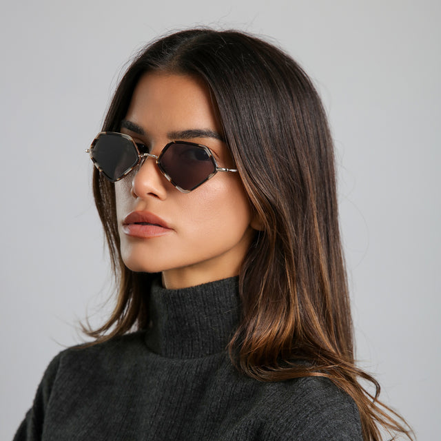 Angled portrait of brunette model in a heather grey cashmere turtleneck wearing Beak Ace 53 Sunglasses White Tortoise/Gold with Grey Flat