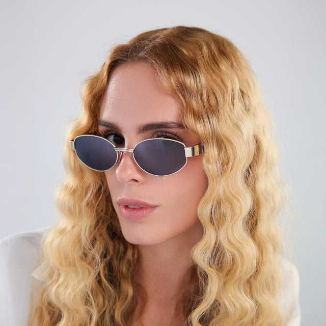 Another angle of blond woman in a white linen blouse wearing Bellagio A Sunglasses Gold/Havana with Grey