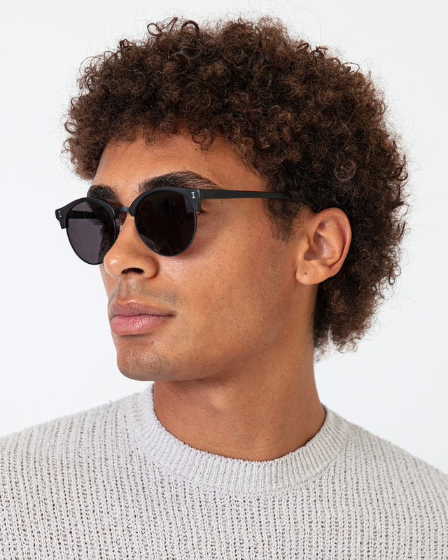 Model with afro-curly hair wearing Benson Sunglasses Matte Black with Grey