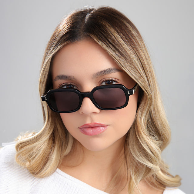 Blond woman in a white blouse wearing Berlin Sunglasses Black with Grey