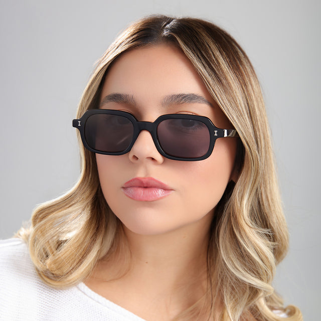 Another angle of blond woman in a white blouse wearing Berlin Sunglasses Black with Grey
