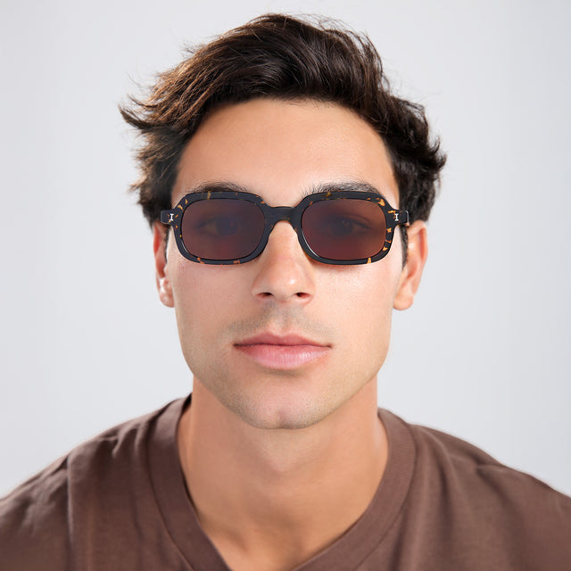 Man with brown hair in a brown shirt wearing Berlin Sunglasses Flame with Brown