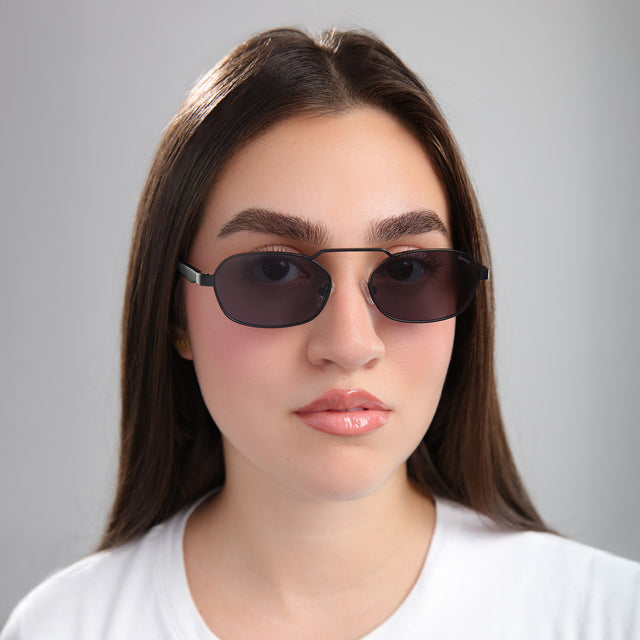 Brunette woman in a white tee wearing Bimini Sunglasses Matte Black with Grey Flat