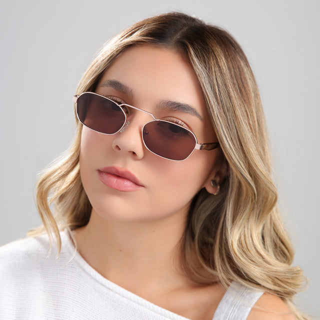 Blond woman in a white blouse wearing Bimini Sunglasses Rose Gold/Havana with Brown Flat