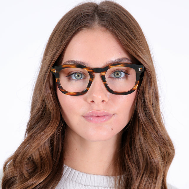 Brunette model with curled hair wearing Boston Optical Dark Sand Optical