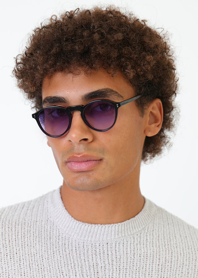 Model with afro-curly hair wearing Capri Sunglasses Green with Purple Gradient