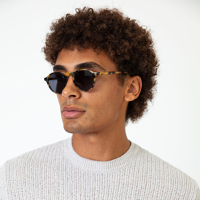 Model with afro-curly hair wearing Capri Sunglasses Tortoise with Grey