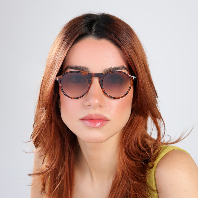 Woman with red hair in a chartreuse blouse wearing Capri Sunglasses Havana with Brown Gradient