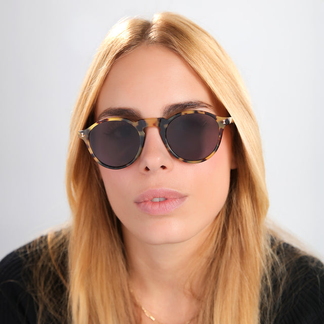 Blond woman in black tee wearing Capri Sunglasses Tortoise with Grey