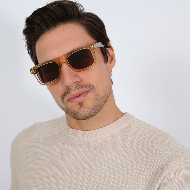 Model with short brown hair in a cream waffle sweatshirt wearing Catania Sunglasses Citrine with Brown Flat