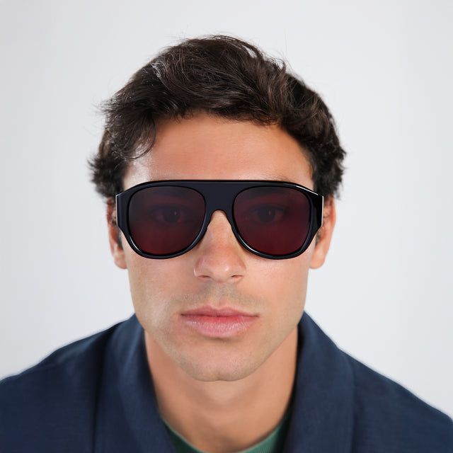Another angle of man in a navy jacket wearing Colorado Sunglasses Black with Plum See Through