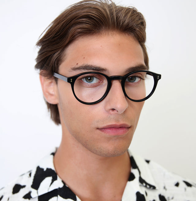 Model with slicked back brown hair wearing Como Optical Black Optical
