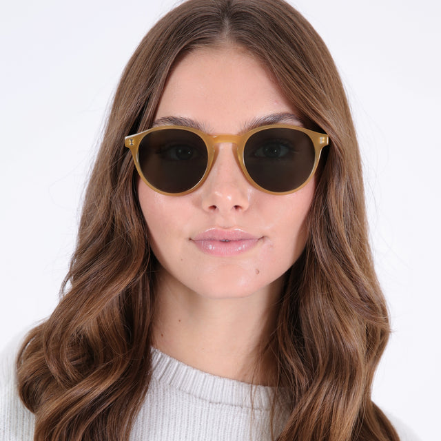 Brunette model with loose curls wearing Como Sunglasses Blond with Olive