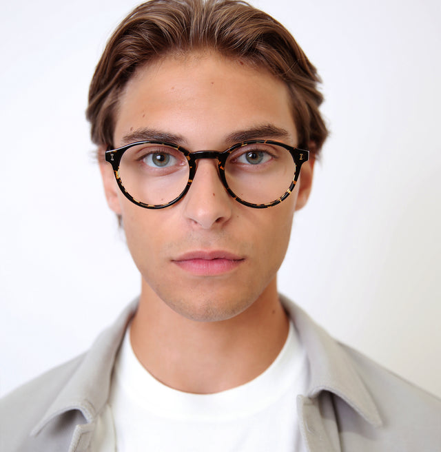 Model with slicked back brown hair wearing Como Optical Flame Optical