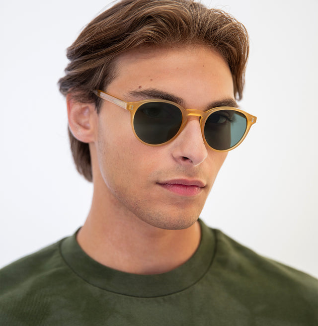 Model with slicked back brown hair wearing Como Sunglasses Blond with Olive