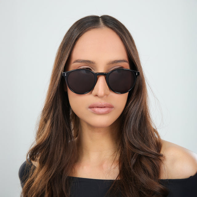 Brunette woman in an off-the-shoulder blouse wearing Como Sunglasses Black with Grey