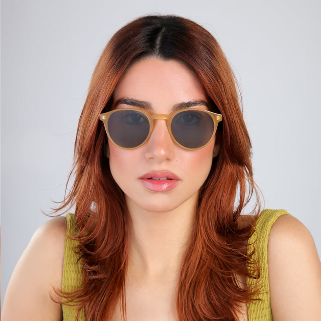 Woman with red hair in a chartreuse blouse looking right Como Sunglasses side view in Blond / Olive