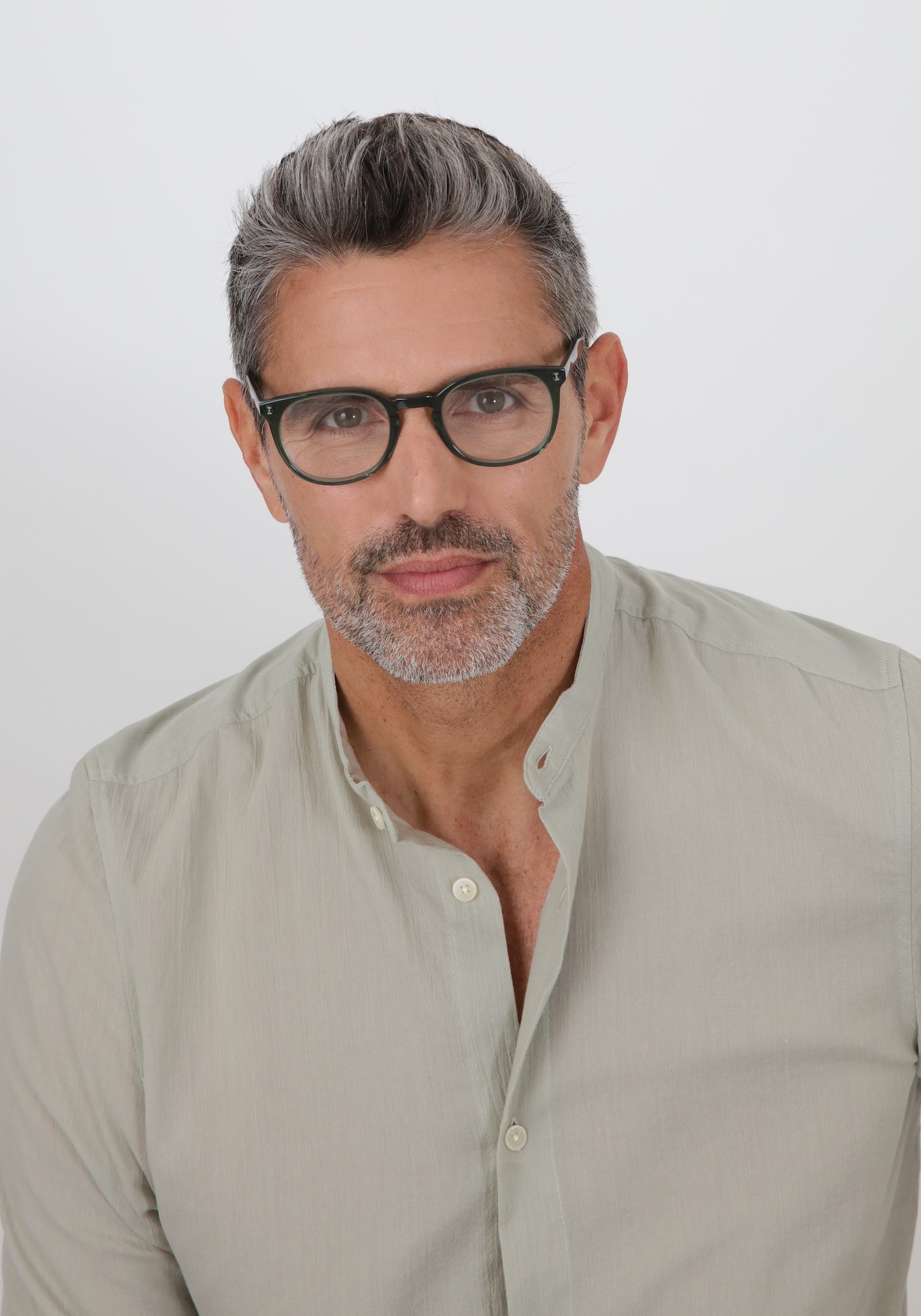 Model with salt and pepper hair and beard in a sage dress shirt wearing Copenhagen Optical in Pine