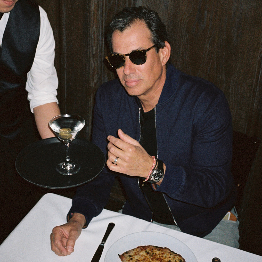 Craig's owner wearing the collaboration frames while being served a martini