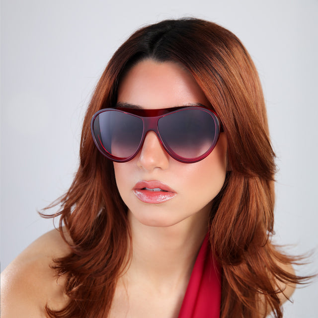 Woman with red hair in a red blouse wearing Cynthia Rowley x illesteva Mulberry with Grey Gradient