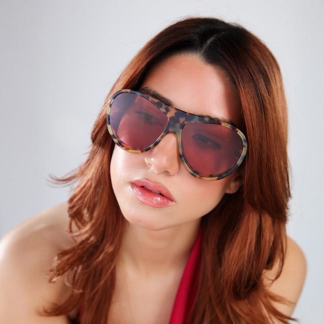 Woman with red hair in a red vest wearing Cynthia Rowley x illesteva Tortoise with Bordeaux See Through