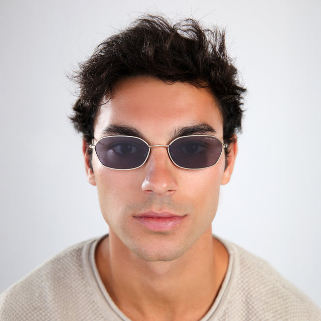 Man with brown hair in a taupe shirt wearing East Houston Sunglasses Gold with Grey Flat