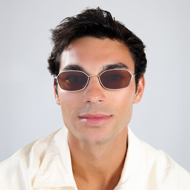 Man with brown hair in a pale yellow linen shirt wearing East Houston Sunglasses Silver with Brown Flat