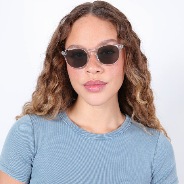 Brunette model with ombre, natural curls wearing Eldridge Sunglasses Clear with Olive Flat