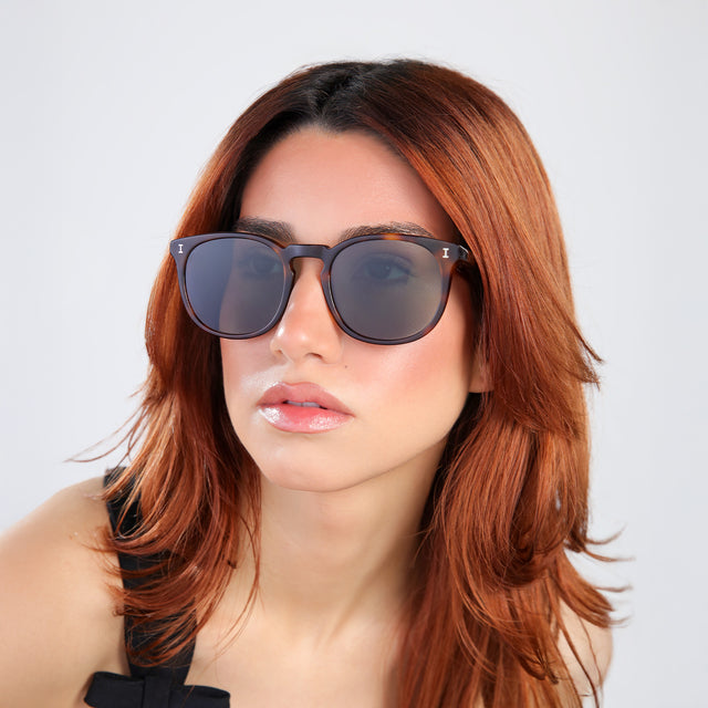 Another angle of woman with red hair in a black blouse wearing Eldridge 56 Sunglasses Havana with Dark Olive Flat