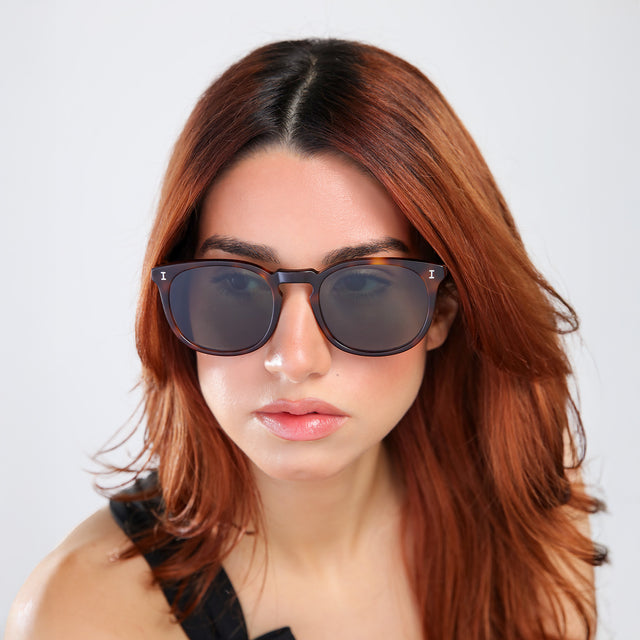 Woman with red hair in a black blouse wearing Eldridge 56 Sunglasses Havana with Dark Olive Flat