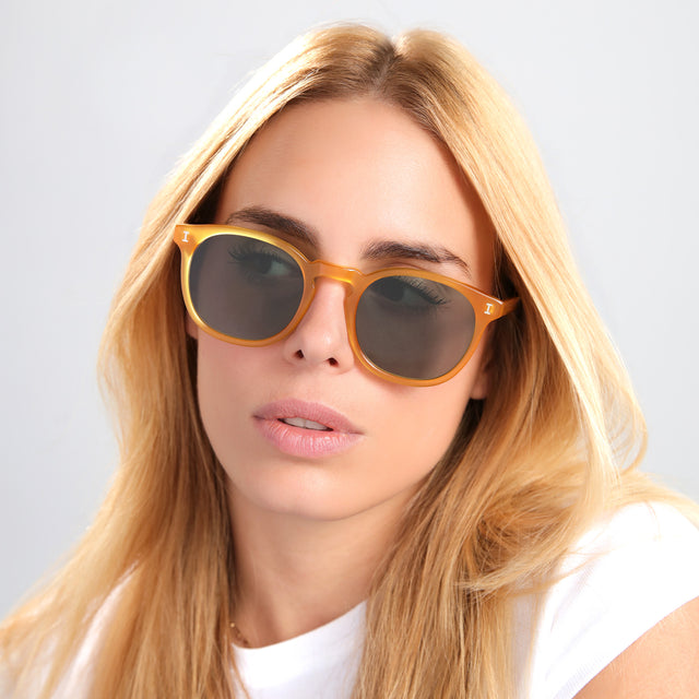 Blond woman in a white tee wearing Eldridge 56 Sunglasses Honey with Olive Flat