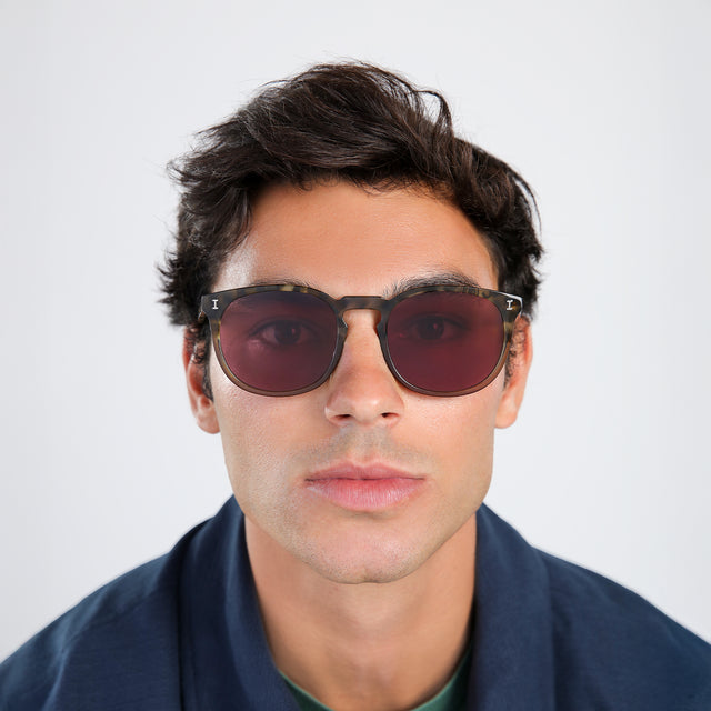 Man in a navy jacket wearing Eldridge 56 Sunglasses Kale with Plum Flat See Through