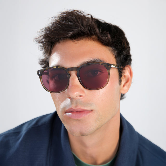 Another angle of man in a navy jacket wearing Eldridge 56 Sunglasses Kale with Plum Flat See Through