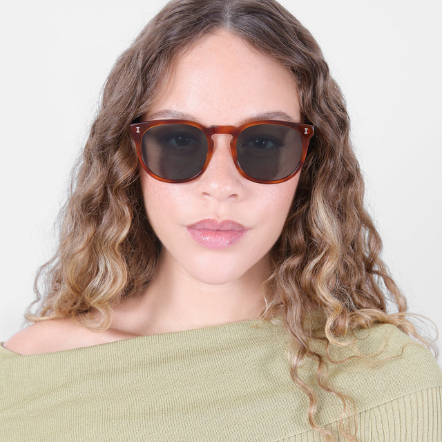 Brunette model with ombré natural curls wearing Eldridge 56 Sunglasses Red Havana with Olive Flat