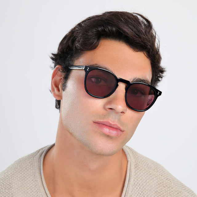 Man with brown hair in a beige, waffled sweatshirt wearing Eldridge Sunglasses Black with Plum Flat See Through