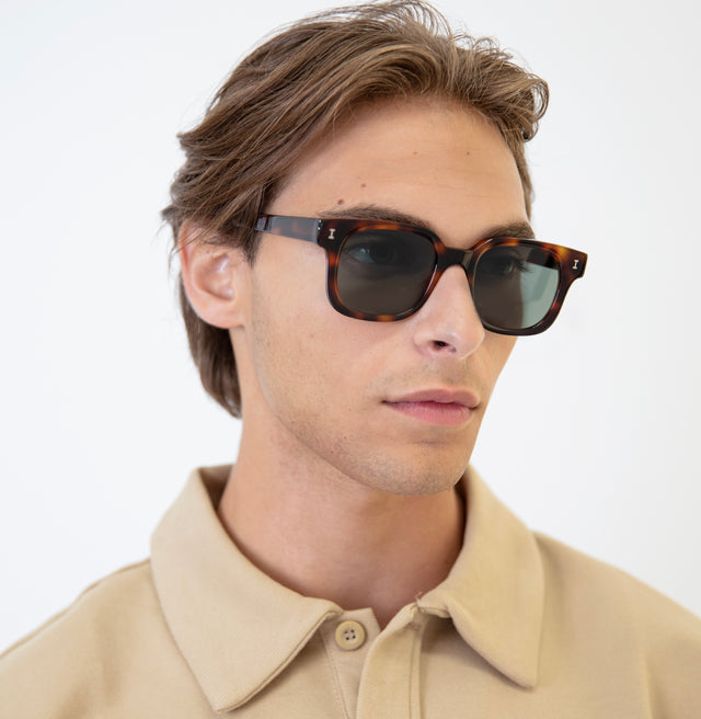 Model with brown hair pushed back wearing Ellison Sunglasses Havana with Olive Flat