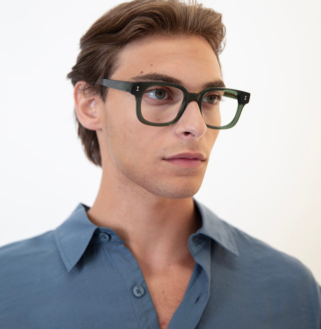 Model with brown hair pushed back wearing Ellison Optical Pine Optical