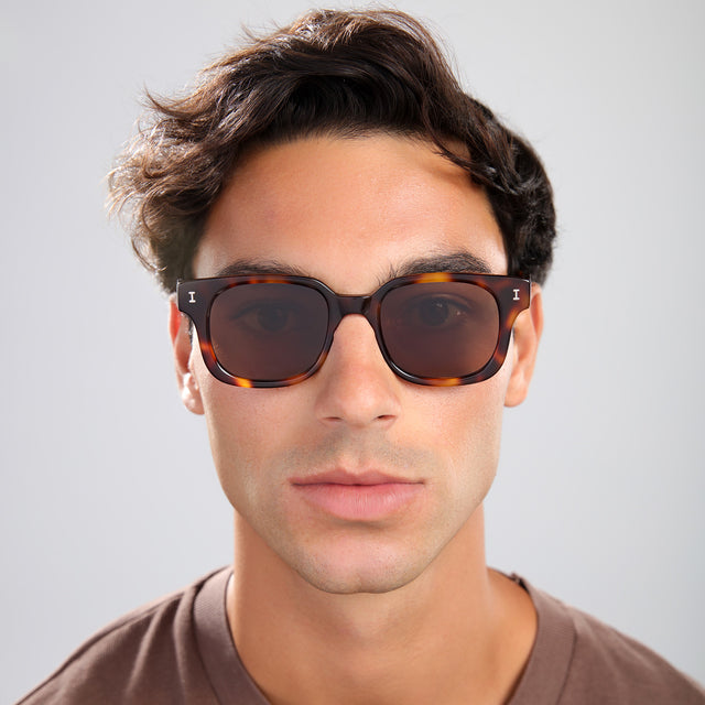 Man with brown hair in a brown shirt wearing Ellison Sunglasses Havana with Brown Flat