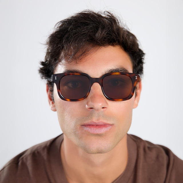 Another angle of man with brown hair in a brown shirt wearing Ellison Sunglasses Havana with Brown Flat